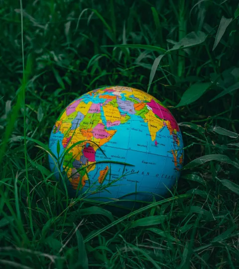 Een kleurrijke wereldbol in een grasveld