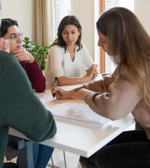 Kleine groep studenten die aan tafel zitten