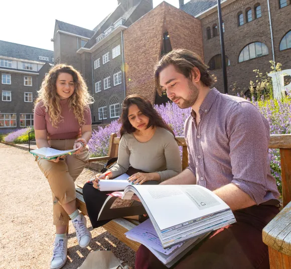 Studenten zijn buiten aan het studeren op de campus van de Radboud Universiteit