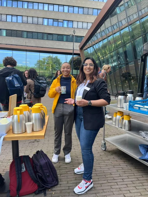 Twee leden van de USR delen koffie uit voor de ingang van De Refter