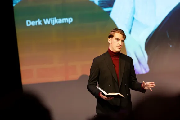Student Derk Wijkamp draagt voor uit een boek