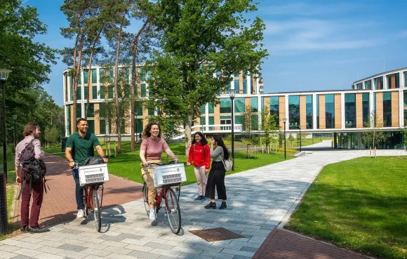 Studenten fietsen en lopen op de campus rondom het Maria Montessorigebouw