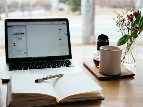 Pen en schrijfblok liggen klaar achter de laptop