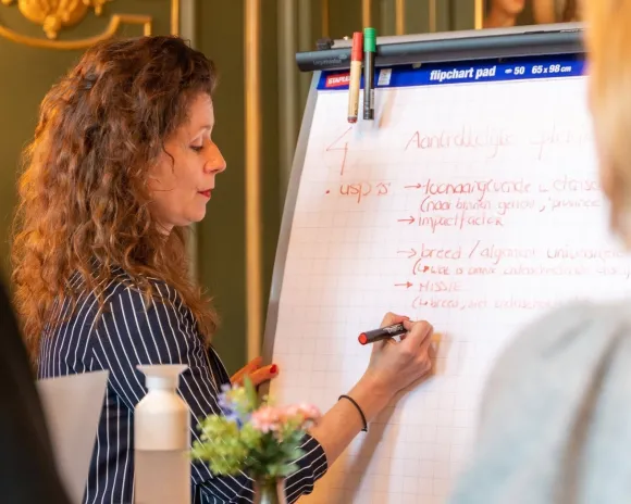 Vrouw schrijft op whiteboard