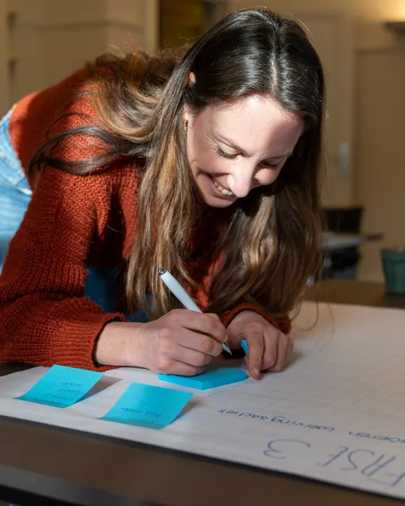 Medewerker schrijft op groot papier