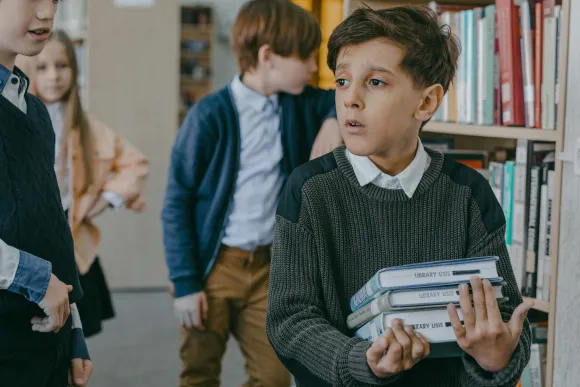School pupil looks lost in a library