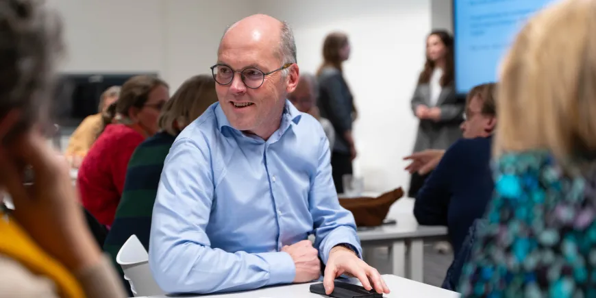 Man in gesprek met anderen in lokaal