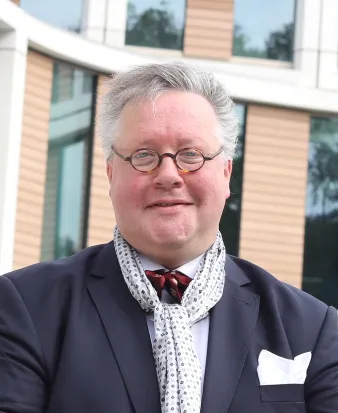 Portret prof. dr. Jos Egger voor het Maria Montessorigebouw