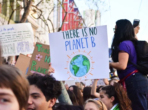 climate protest with someone holding a sign reading 'there is no planet B'
