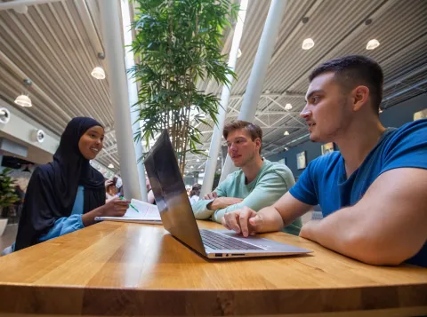 Studenten aan tafel met laptop in De Refter
