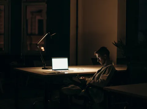 Man in donkere kamer met laptop