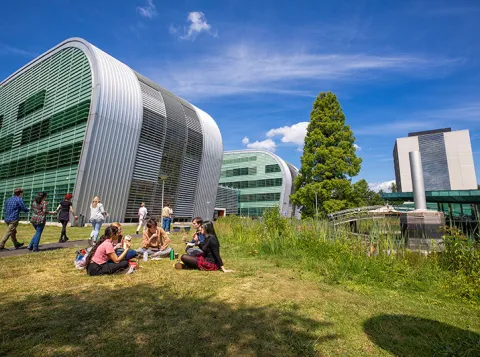 Studenten in het gras voor het Huygensgebouw