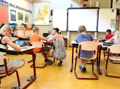 Kinderen in een klaslokaal onder begeleiding van een leraar