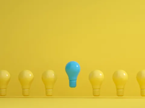 Row of yellow light bulbs and one blue one