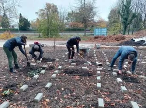 Medewerkers en studenten graven in een moestuin