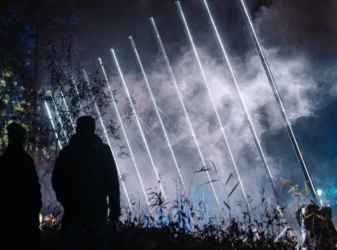 People observing an exposition in the dark