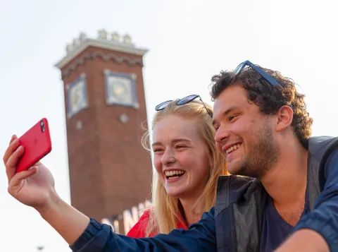 Studenten die een foto nemen voor het centraal station in Nijmegen