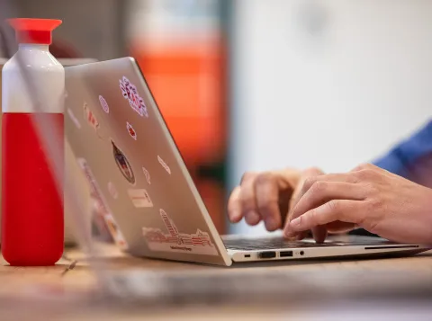 Een persoon typt op een laptop
