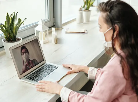 Two people video calling each other with face masks on