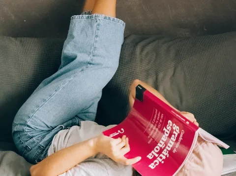 Girl reading a Spanish textbook upside down