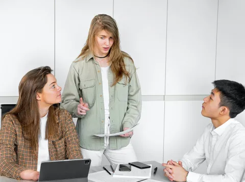 Three students talking to each other in a school setting