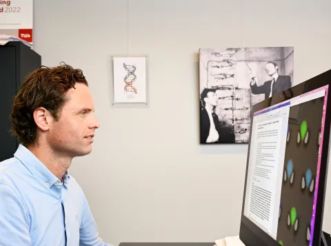 Hoogleraar Tom de Greef kijkt naar een computerscherm met beeld van DNA-dataopslag