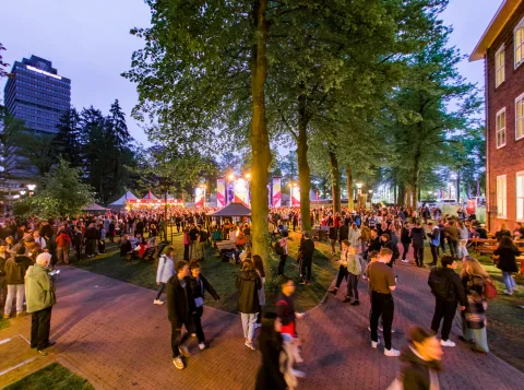 Foto van vol grasveld en podium naast Berchmanianum tijdens Radboud Festival