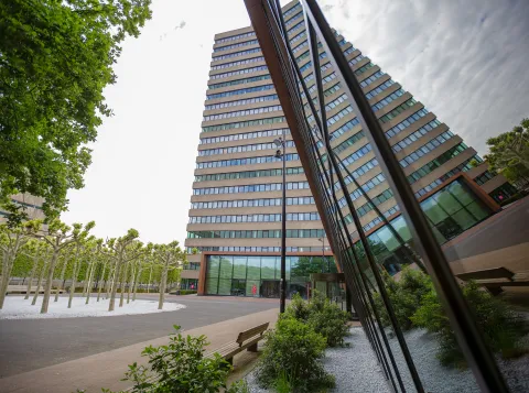 Het Erasmusgebouw dat reflecteert in het raam van de Refter