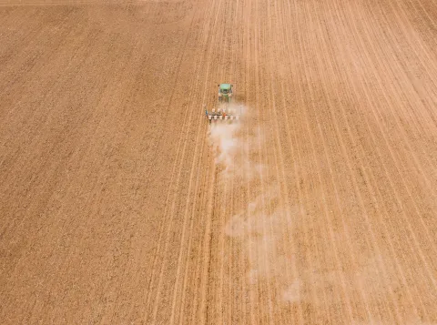 Modern backhoe ploughing agricultural field