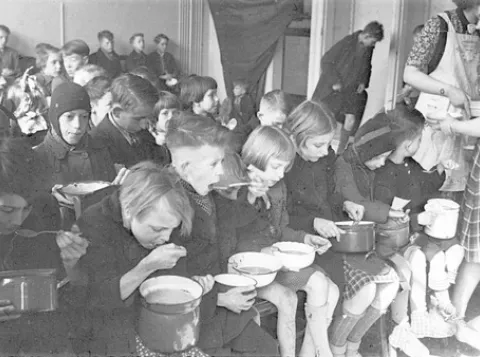 Kinderen kregen een halve liter bijvoeding per dag tijdens de Hongerwinter, verschaft door het Interkerkelijk Bureau. Foto gemaakt in opdracht van het IKB.
