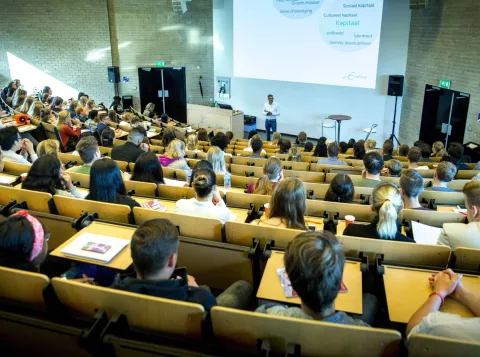 Docent geeft les in een grote collegezaal