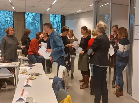 Groep cursisten staand in een klaslokaal