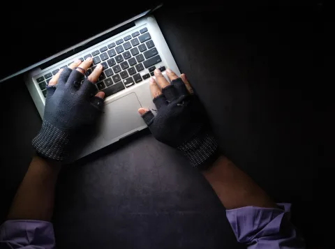 handen met handschoen en laptop