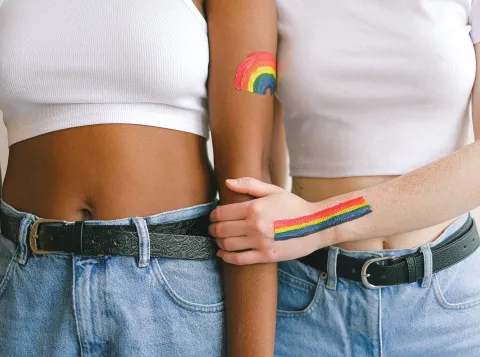 two people holding each other with rainbows painted on them 