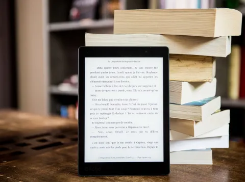Ebook met gedrukte boeken op de achtergrond