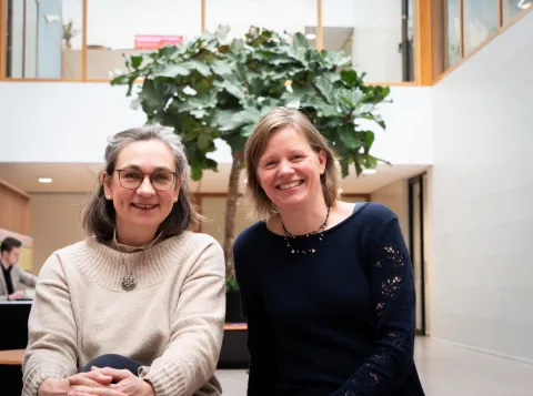 Tesseltje De Lange en Karen Geertsema op een bankje in het Grotiusgebouw