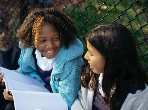 Smiling multiethnic girls with copybooks