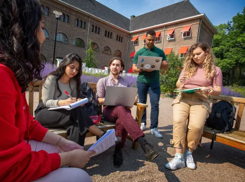 Groep studenten aan het werk buiten op de campus