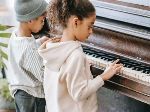Twee kinderen achter een piano