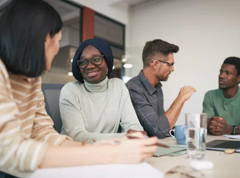 Vier personen aan tafel in gesprek