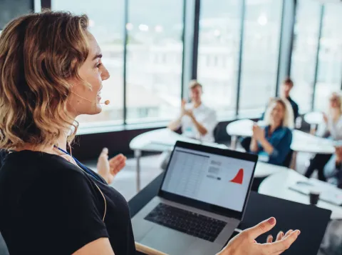Vrouw geeft een presentatie voor publiek