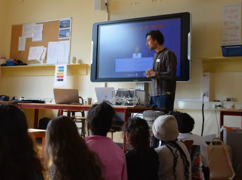 Jasper de Groot staat voor de klas en geeft uitleg aan basisschoolleerlingen