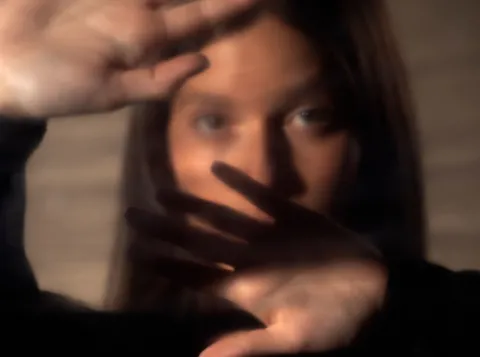 Vrouw met hand voor gezicht