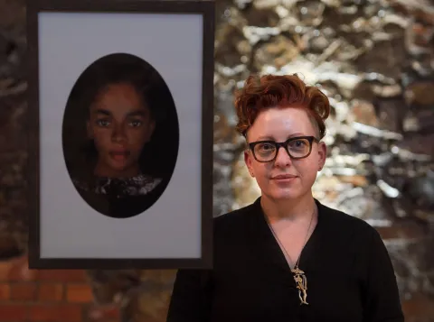Artist Kathryn Smith poses next to reconstructed portrait of fugitive enslaved person