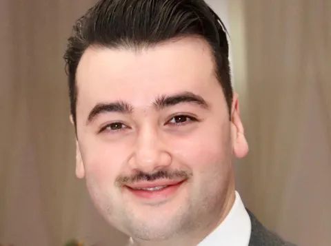 Picture of a young man with short hair and a mustache 
