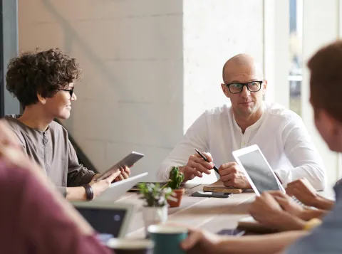 Personen in gesprek aan een tafel in zakelijke setting