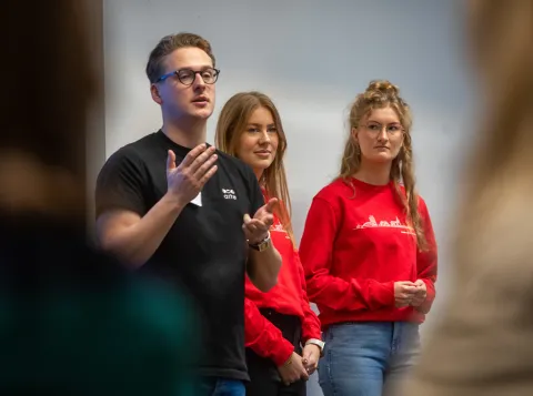 Foto van drie studentmedewerkers die een praatje geven tijdens de Bachelor Open Dag 2023.