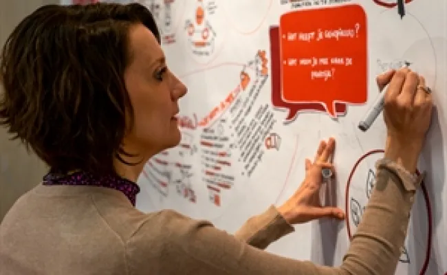 Lecturer writes on whiteboard
