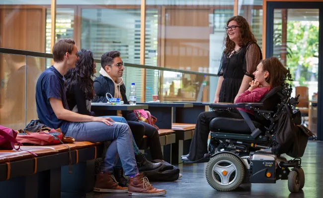Woman in wheelchair in canteen Grotiusgebouw