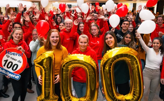 Studenten Rechtsgeleerdheid met ballonnen en een groot cijfer honderd